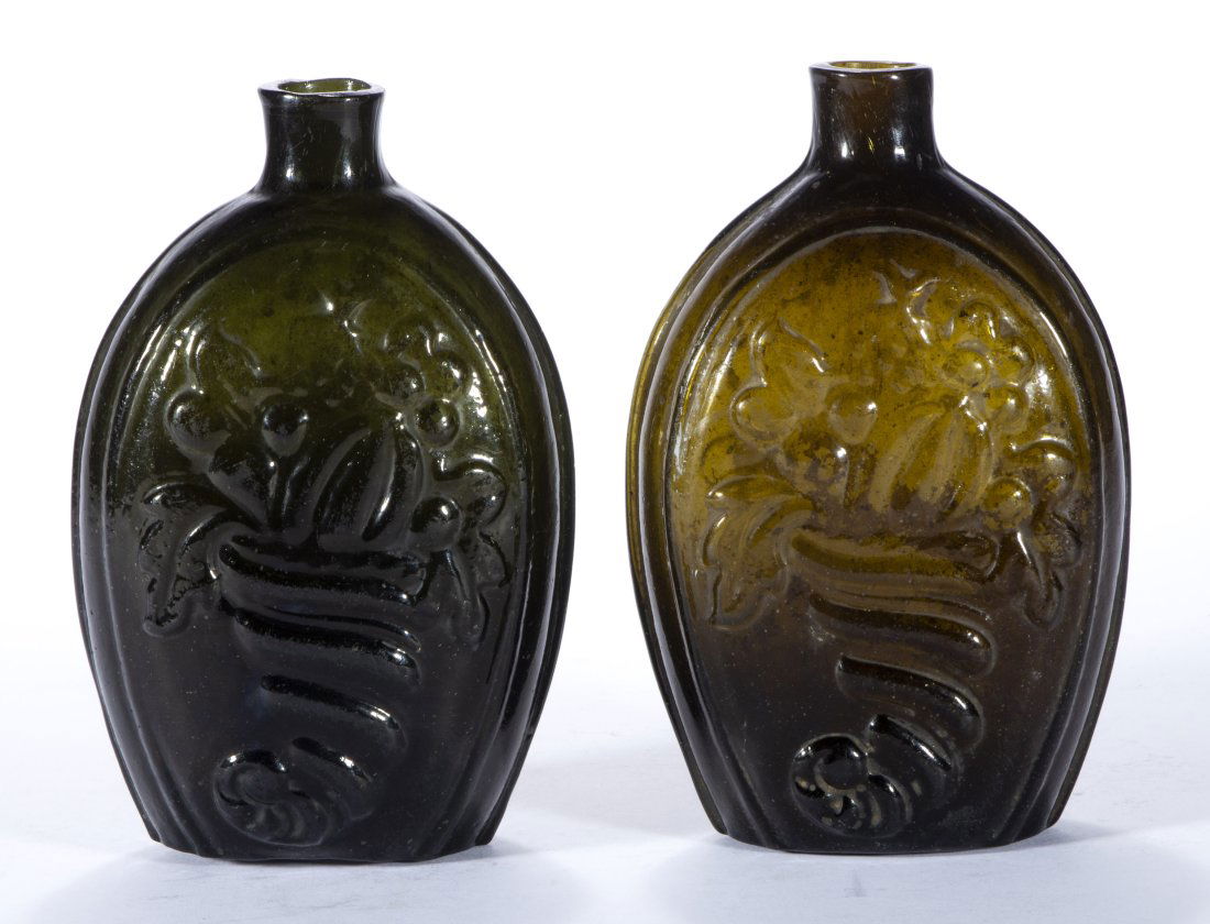 GIII-4 CORNUCOPIA - URN PICTORIAL FLASKS, LOT OF TWO,: yellow-olive and olive-green, each being pint size and having a rough pontil mark. Coventry Glassworks (1815-1848), Coventry, Connecticut. 1820-1848. 6 1/2" and 6 3/4" H.Literature: McKearin/Wilson -