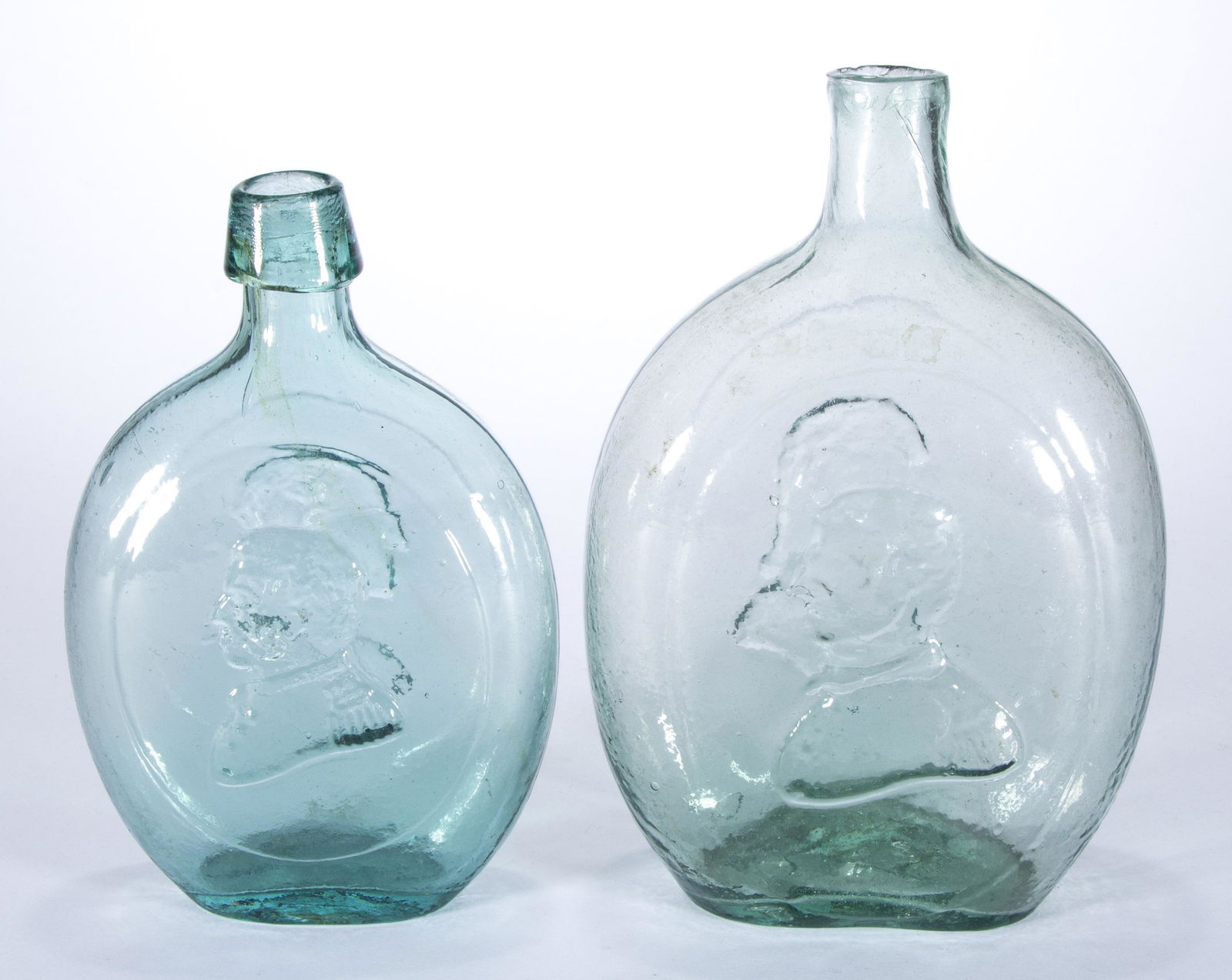 ASSORTED WASHINGTON / TAYLOR HISTORICAL FLASKS, LOT OF TWO,: comprising a light green quart GI-51, and a blue/green pint GI-52 with an applied lip, each having a rough pontil mark. Probably Dyottville Glass Works. 1840-1860. 7 3/8" and 8 3/8" H.Provenance: From