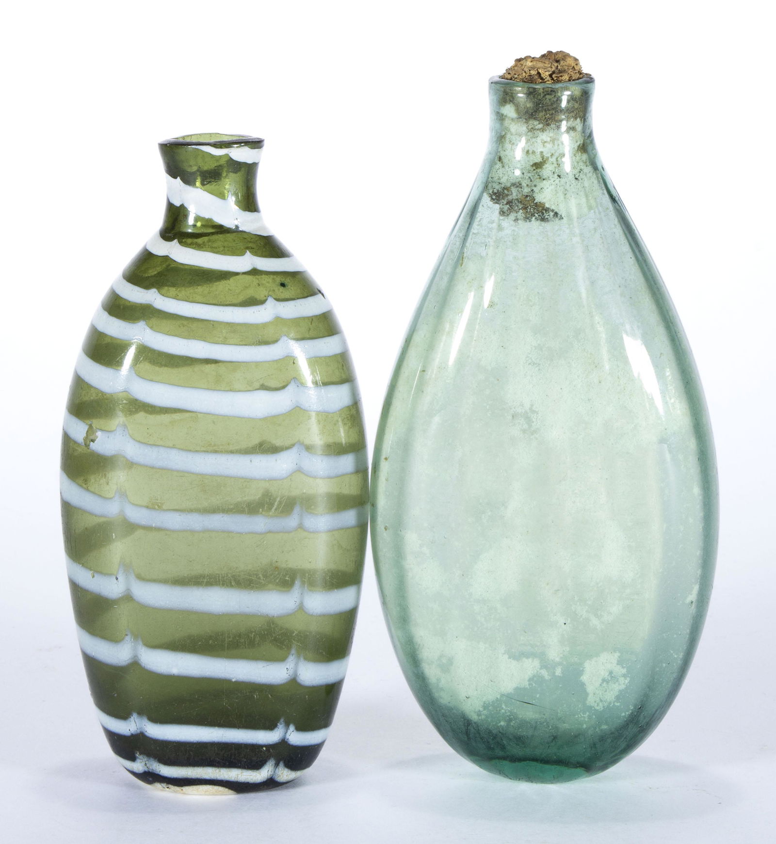 ASSORTED BLOWN GLASS FLASKS, LOT OF TWO,: comprising an olive green wave-decorated with opal decoration, and an aquamarine pattern-molded example with vertical ribs, each having a plain mouth and rough pontil mark. Various makers. 19th centur