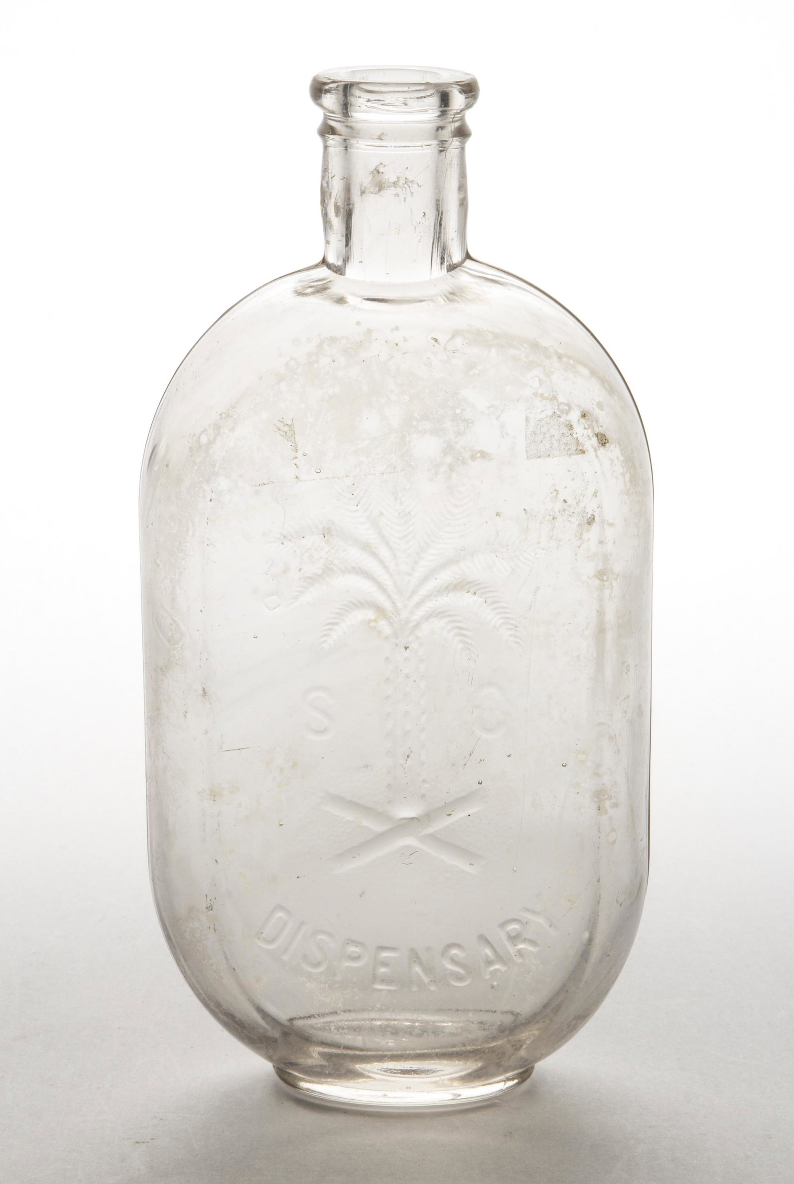 SOUTH CAROLINA DISPENSARY OVAL FLASK,: colorless, pint, embossed "S (palmetto tree) C / DISPENSARY", rounded collared mouth, smooth base. Fourth quarter 19th century. 8" H. Provenance: From the Eddie Tatum estate collection, Winston-Salem,