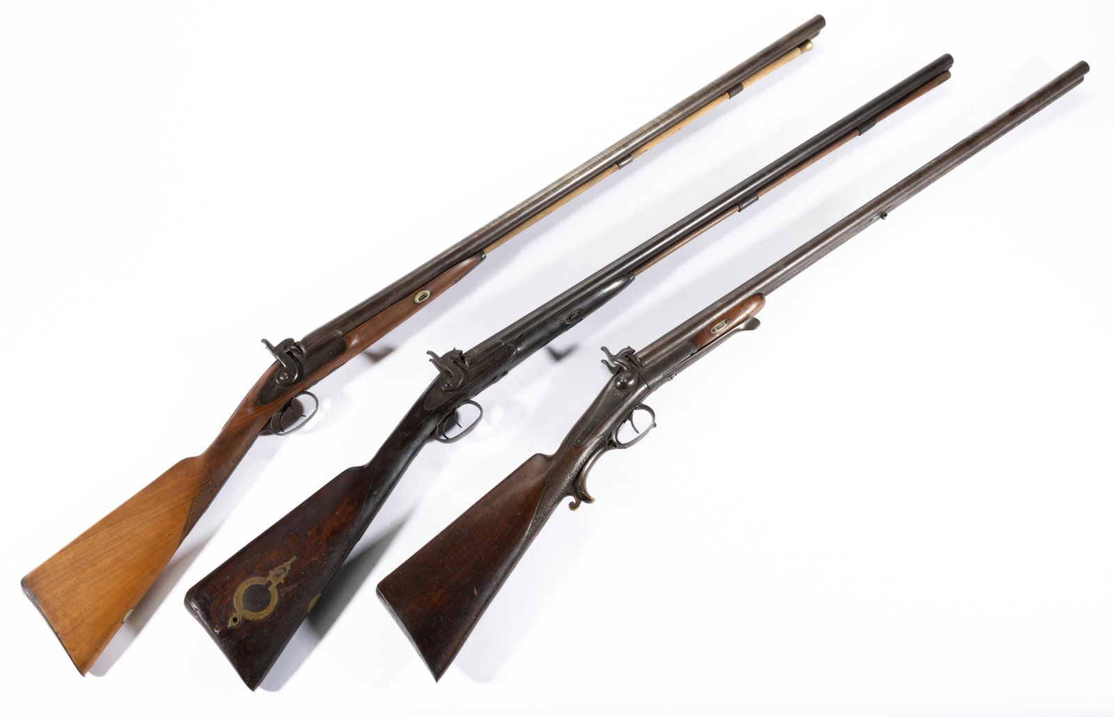 ANTIQUE PERCUSSION DOUBLE-BARREL SHOTGUNS, LOT OF THREE,: markings include "Manton", "Hollis & Sheath", and "Carl Becker", one with patch box. Class: Antique. Second half 19th century. 47 1/2" to 50" LOA. Provenance: From the Collin Smither collection, Staun