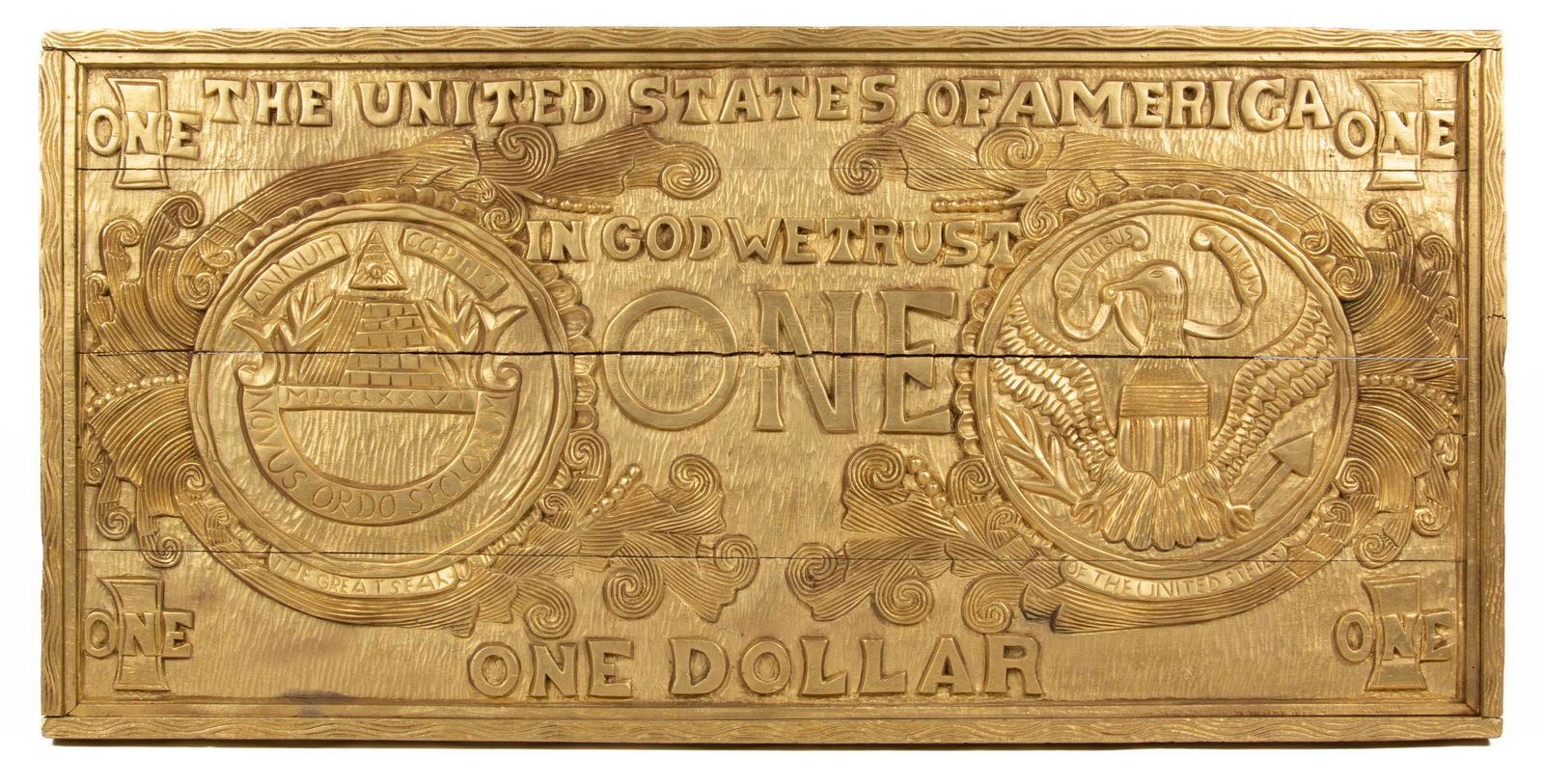 FOLK ART CARVED AND PAINTED ONE DOLLAR BILL,: singled-sided, large depiction of the United States of American one dollar bill, no signature located. Retains likely original gilt-painted surface. 20th century. 25" x 52". Provenance: From an import