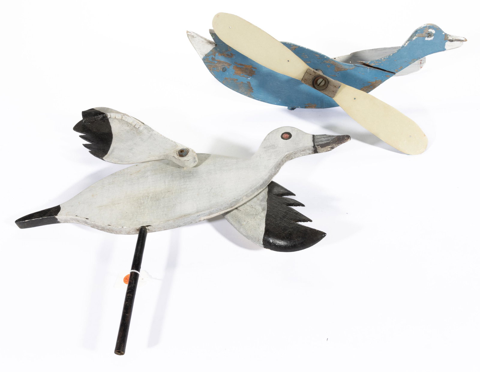 AMERICAN FOLK ART PAINTED DUCK WHIRLIGIGS, LOT OF TWO,: each featuring rotating wings, white painted example with carved bill. Each with original polychrome painted surface. 20th century. One 13" HOA, 21" L. Provenance: From the collection of Robert and Ma