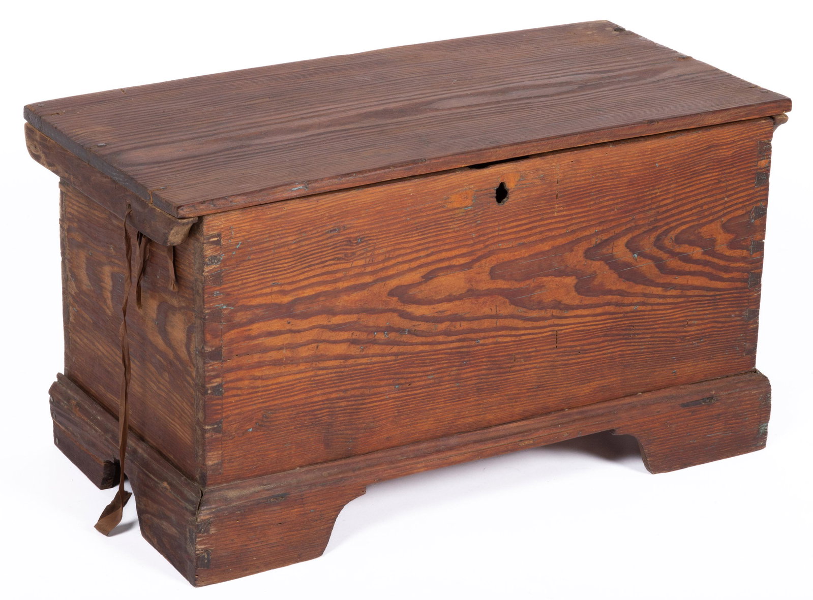 VIRGINIA YELLOW PINE CHILD'S BLANKET CHEST,: hinged rectangular lid with battens affixed to the underside, over a dovetailed case, with applied bracket feet, sides with cut-outs. Retains an old refinished surface with warm color. First half 19th