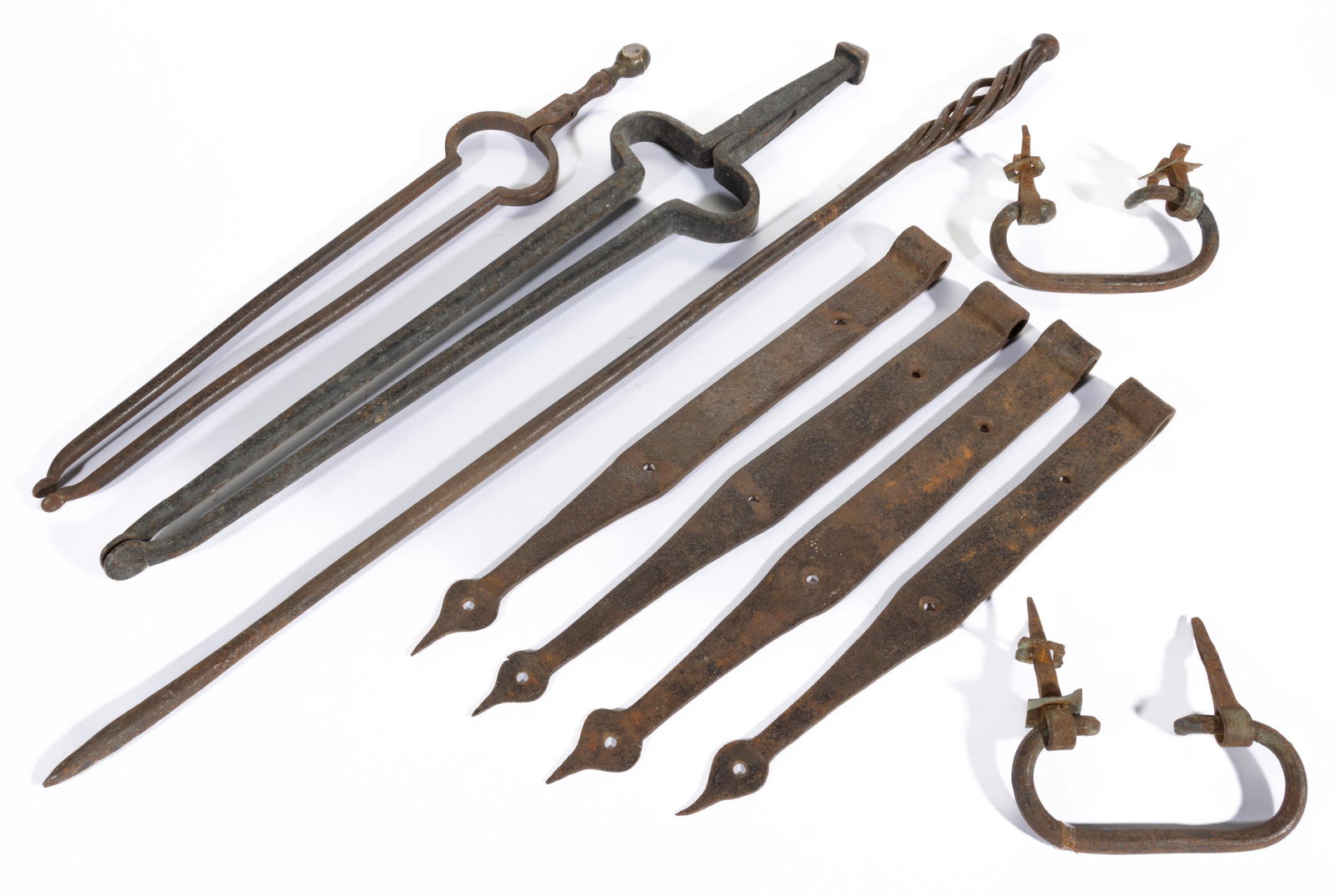 ASSORTED SHENANDOAH VALLEY OF VIRGINIA AND OTHER WROUGHT-IRON ARTICLES, LOT OF NINE,: comprising a set of four strap hinges, a pair of blanket chest bail handles with mounts, a fireplace poker having an open-spiral handle, and two fire tongs, one with brass finial. Late 18th to early 2