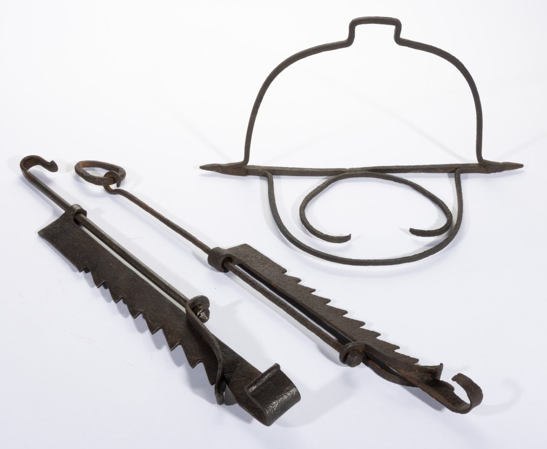 ASSORTED WROUGHT-IRON HEARTH ARTICLES, LOT OF THREE,: comprising two bar trammels and a hanging trivet. Each with excellent early surface. 18th century. 24" and 27" L contracted.
