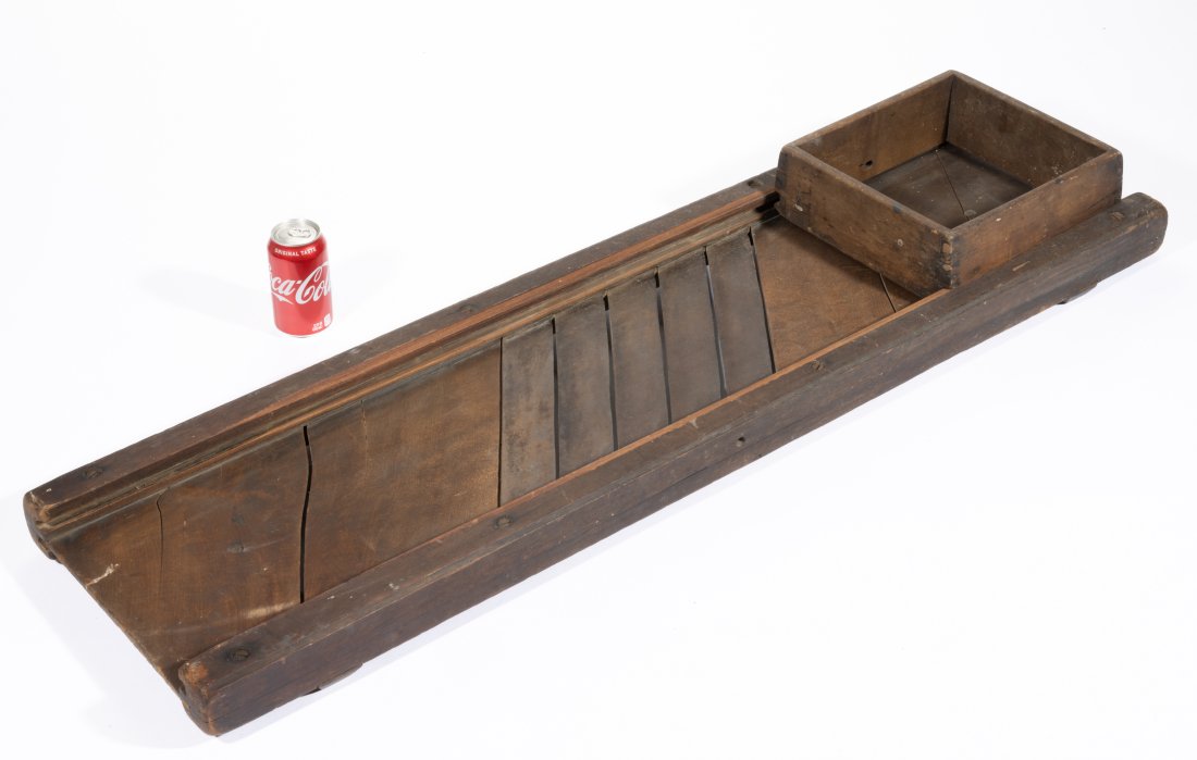 SHENANDOAH VALLEY OF VIRGINIA WALNUT OVERSIZED SLAW BOARD,: bed set with five cutting blades, side rails with molded edges, original dovetailed sliding cutter box. Retains original dry surface. Mid 19th century. 49 1/2" LOA, 14" W, 11" x 10" box. Provenance: F