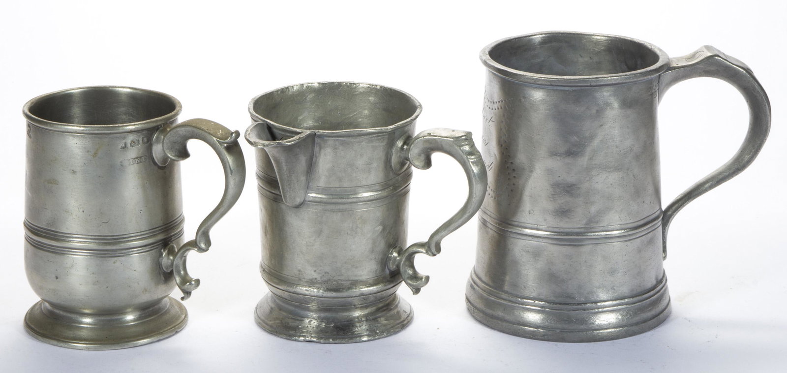 ASSORTED ENGLISH - LONDON PEWTER MUGS, LOT OF THREE,: comprising two pint footed examples with scroll handles, including one with a pour spout marked for Farrow and Grimes, underside with engraved "Blue Anchor, Dochid?" and numerals "703820621", and othe