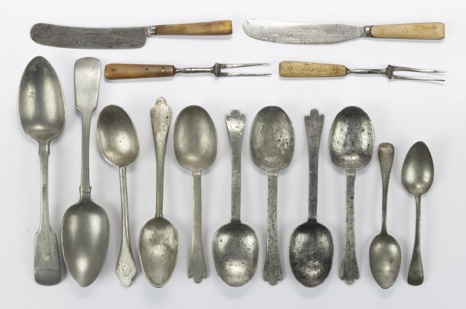 ASSORTED ENGLISH PEWTER UTENSILS, LOT OF 15,: including five trifid tablespoons, two fiddleback serving spoons by Thould, two teaspoons marked "BEST BRITANNIA", two knife and fork assembled sets with wooden handles, forks with double tines, blade