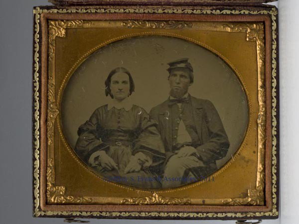 CIVIL WAR SOLDIER SIXTH-PLATE AMBROTYPE: CIVIL WAR SOLDIER SIXTH-PLATE AMBROTYPE, lightly tinted, in full uniform with kepi, seated beside a lady. Leather-covered snap case. Third quarter 19th century. 3 5/8" x 3 1/8" case. Provenance: Penn