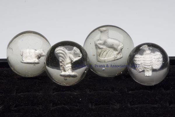 FOUR ANIMAL FIGURE SULPHIDE MARBLES: FOUR ANIMAL FIGURE SULPHIDE MARBLES, depicting a spread-wing eagle, a squirrel eating a nut, a bear (?), and a rearing horse, each with a light pontil mark. Late 19th/early 20th century. 1 5/16" to 1