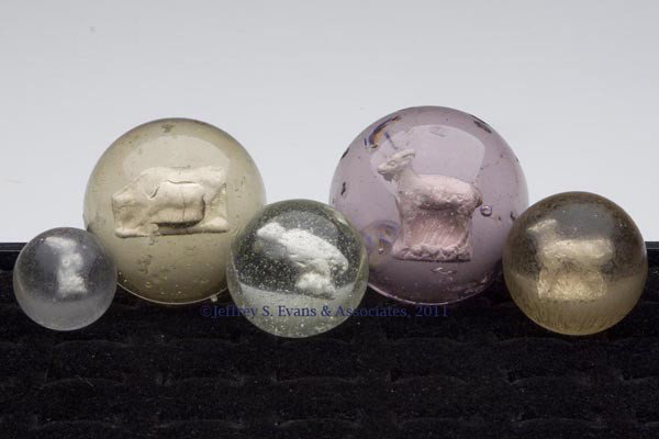 FIVE ANIMAL FIGURE SULPHIDE MARBLES: FIVE ANIMAL FIGURE SULPHIDE MARBLES, various figures, largest with purple tint, each with a light pontil mark. Late 19th/early 20th century. 1 1/16" to 2 1/8" D.