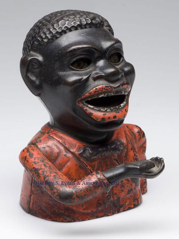 "JOLLY NIGGER BANK" CAST-IRON MECHANICAL BANK: "JOLLY NIGGER BANK" CAST-IRON MECHANICAL BANK, also lettered "PAT. MAR. 14 '82" on back, original paint, lacking base plate. Fourth quarter 19th century. 6 1/2" H.