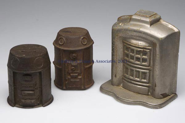THREE FIGURAL CAST-IRON STILL BANKS: THREE FIGURAL CAST-IRON STILL BANKS, comprising a Marshall stove, a "MELLOW" stove with lettering on reverse, and a "SOCIETE ANONYME / LES / FORGES DE CINEY / BELGIQUE" fireplace, each with original s