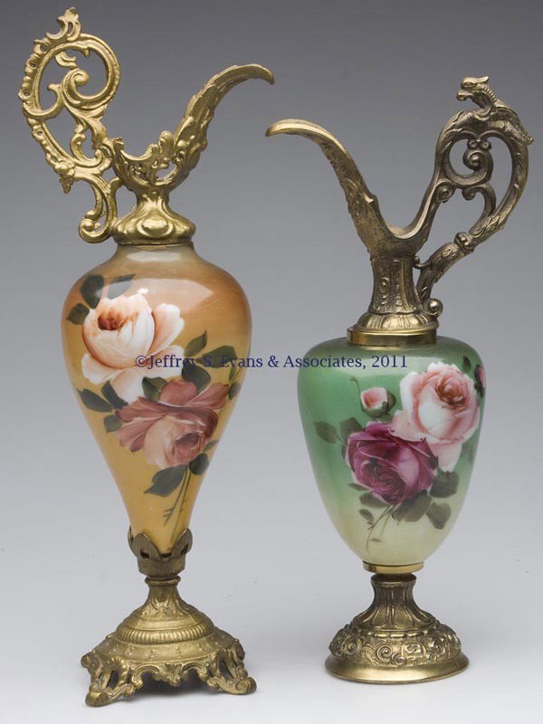 TWO DECORATED OPAL GLASS MANTEL EWERS: TWO DECORATED OPAL GLASS MANTEL EWERS, each of bolted construction with metal mounts, one with later gold paint. Late 19th/early 20th century. 15" and 17 1/2" HOA. Provenance: Property of a Northern