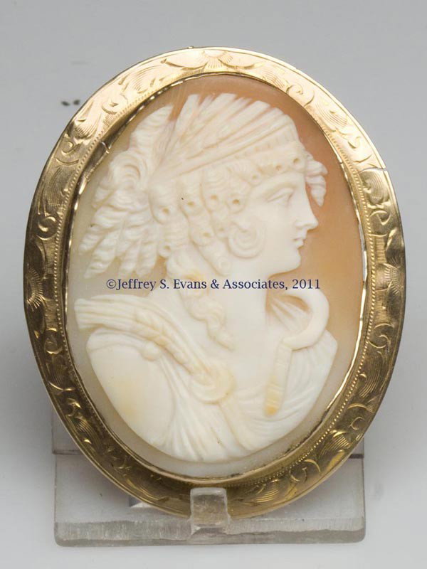 GOLD AND SHELL CAMEO BROOCH: GOLD AND SHELL CAMEO BROOCH, depicting a lady with sickle and grain, frame marked 10K. First quarter 20th century. 2" x 2 3/8". Provenance: Property of a Northern Virginia collector.