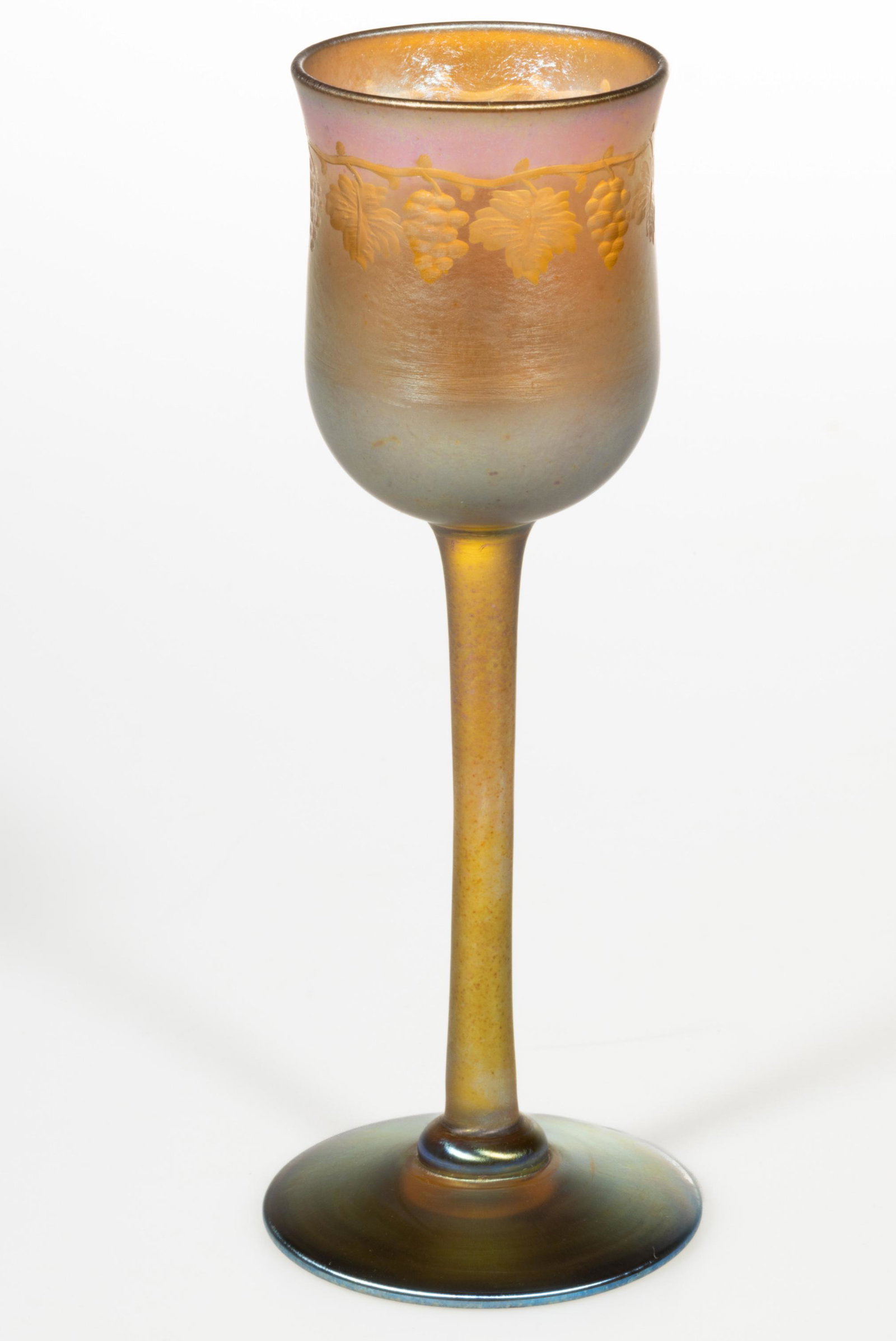 TIFFANY STUDIOS GRAPEVINE ENGRAVED IRIDESCENT ART GLASS WINE,: TIFFANY STUDIOS GRAPEVINE ENGRAVED IRIDESCENT ART GLASS WINE, golden iridescent, grapevine engraving just below the rim, tall thin stem, applied circular foot, signed to the underside "L. C. T.", poli