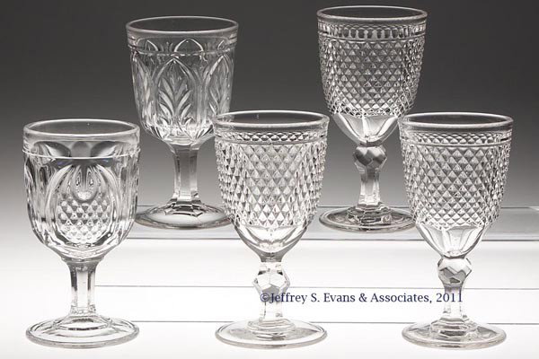 VARIOUS EAPG GOBLETS, LOT OF FIVE: VARIOUS EAPG GOBLETS, LOT OF FIVE, colorless lead glass, comprising three Diamond Point, New England Pineapple and Arched Leaf. Third quarter 19th century. 6" to 6 1/2" H.