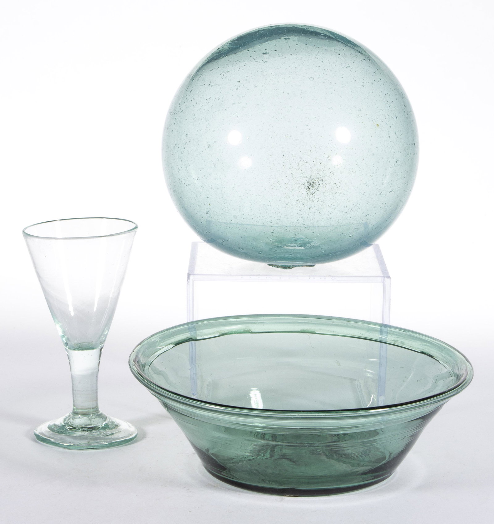 ASSORTED BLOWN GLASS ARTICLES, LOT OF THREE: ASSORTED BLOWN GLASS ARTICLES, LOT OF THREE, comprising a light green pan with a rolled-over rim, an aquamarine witch ball with a rough pontil opening, and an aquamarine wine with a conical bowl. Vari