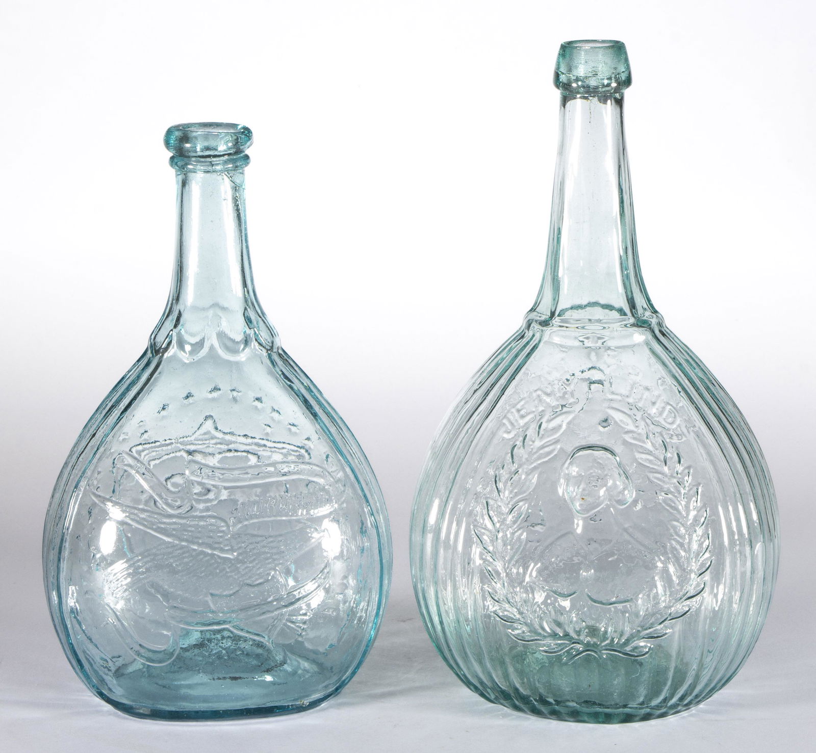 GI-102 AND GIV-42 VARIANT FLASKS, LOT OF TWO: GI-102 AND GIV-42 VARIANT FLASKS, LOT OF TWO, light green and medium blue/green, each calabash form with one being a Jenny Lind, other being a shield and clasped hands, rough pontil marks. Various mak