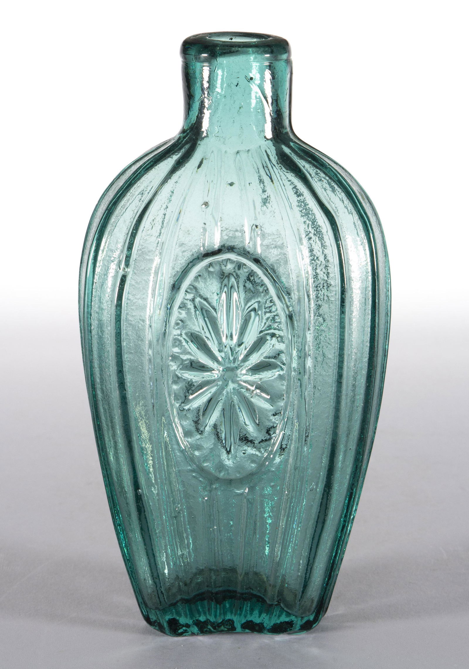 GVIII-29 SUNBURST FLASK: GVIII-29 SUNBURST FLASK, strong bluish green, three-quarter-pint, plain mouth, rough pontil mark. United States. 1830-1850. 6 7/8" H. Literature: McKearin/Wilson - American Bottles & Flasks, p. 615. P