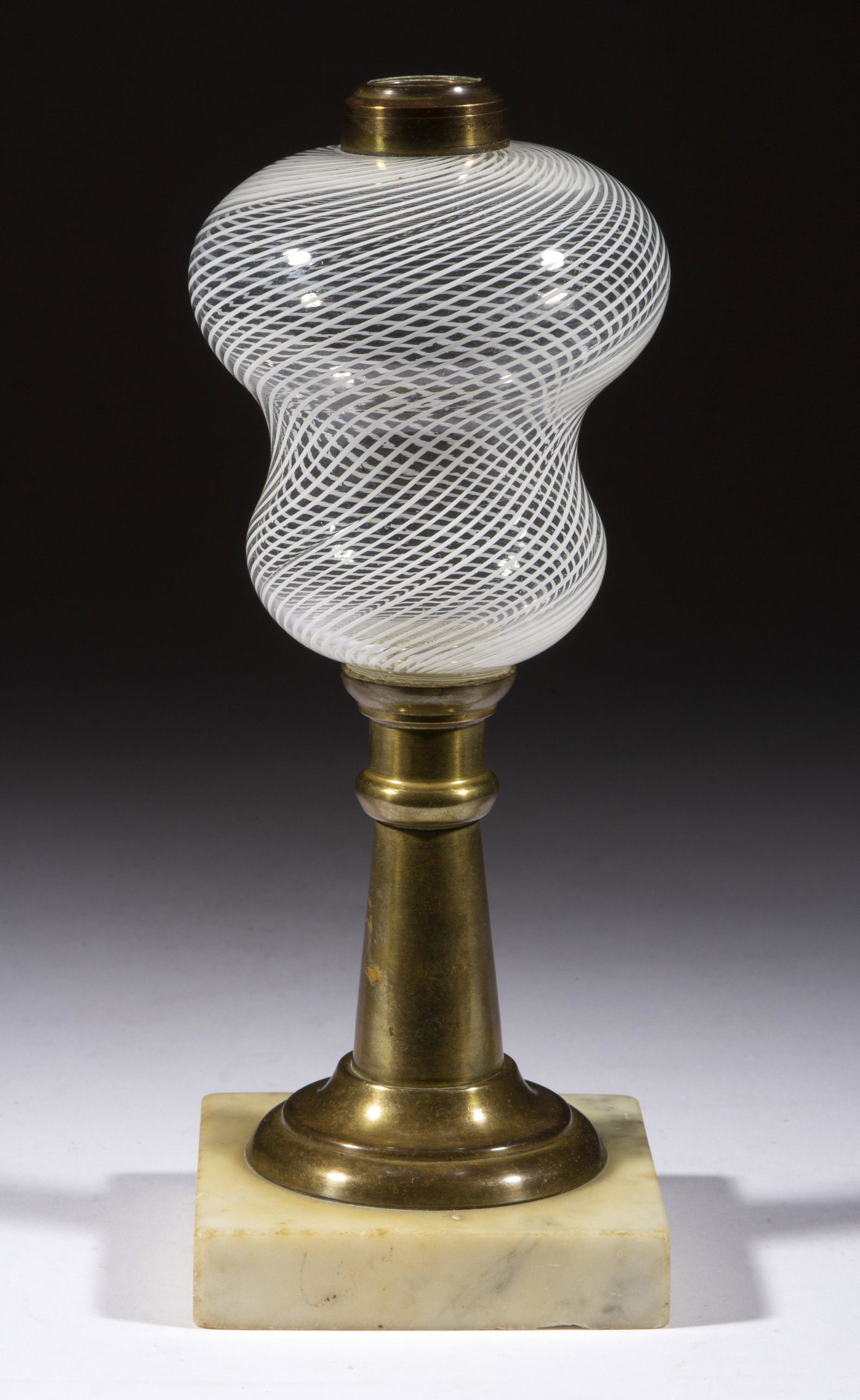 LATTICINIO STRIPE KEROSENE STAND LAMP: LATTICINIO STRIPE KEROSENE STAND LAMP, colorless with opal swirling, waisted font raised on a simple brass stem and single-step marble base, period No. 1 brass collar. Probably the shop of Nicholas Lu