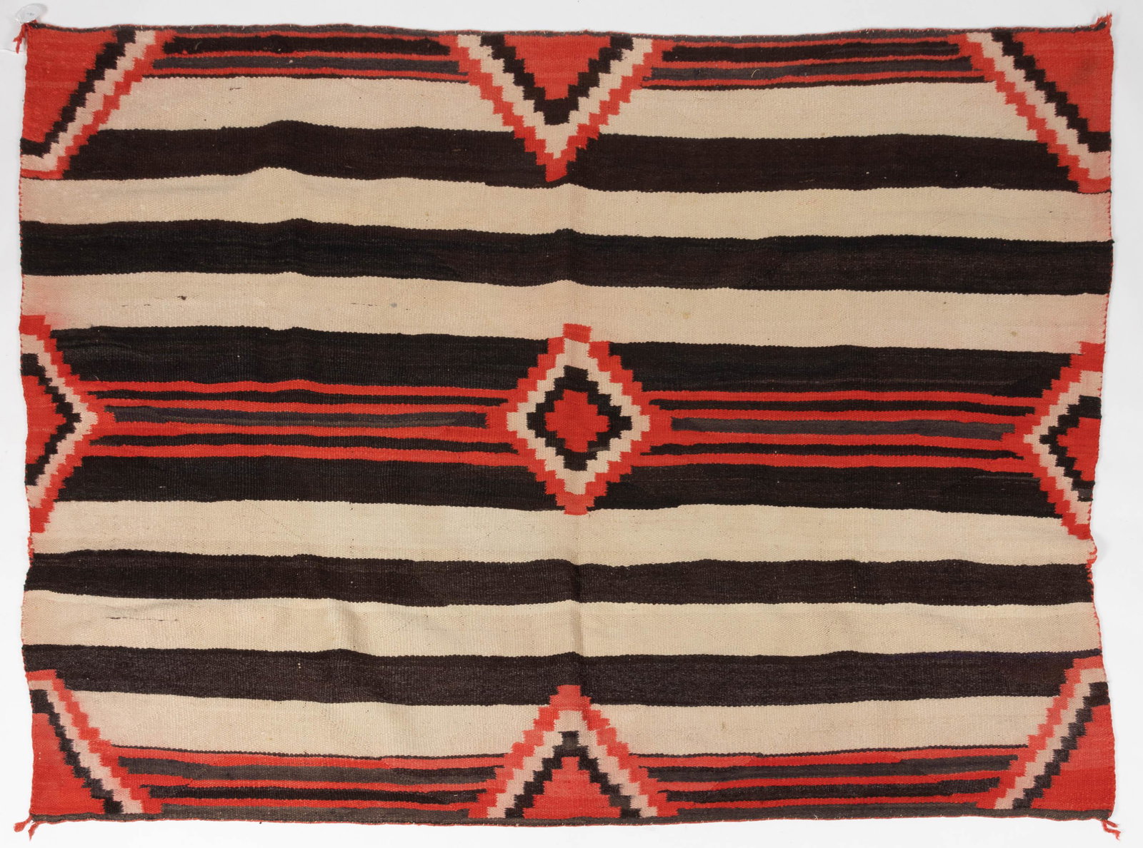 NATIVE AMERICAN NAVAJO THIRD PHASE CHIEF'S STYLE WOOL WEARING BLANKET: NATIVE AMERICAN NAVAJO THIRD PHASE CHIEF'S STYLE WOOL WEARING BLANKET, colors comprising white, black-brown, and red, featuring stepped diamond motifs, several sectioned or "lazy" lines. Circa 1900. 6