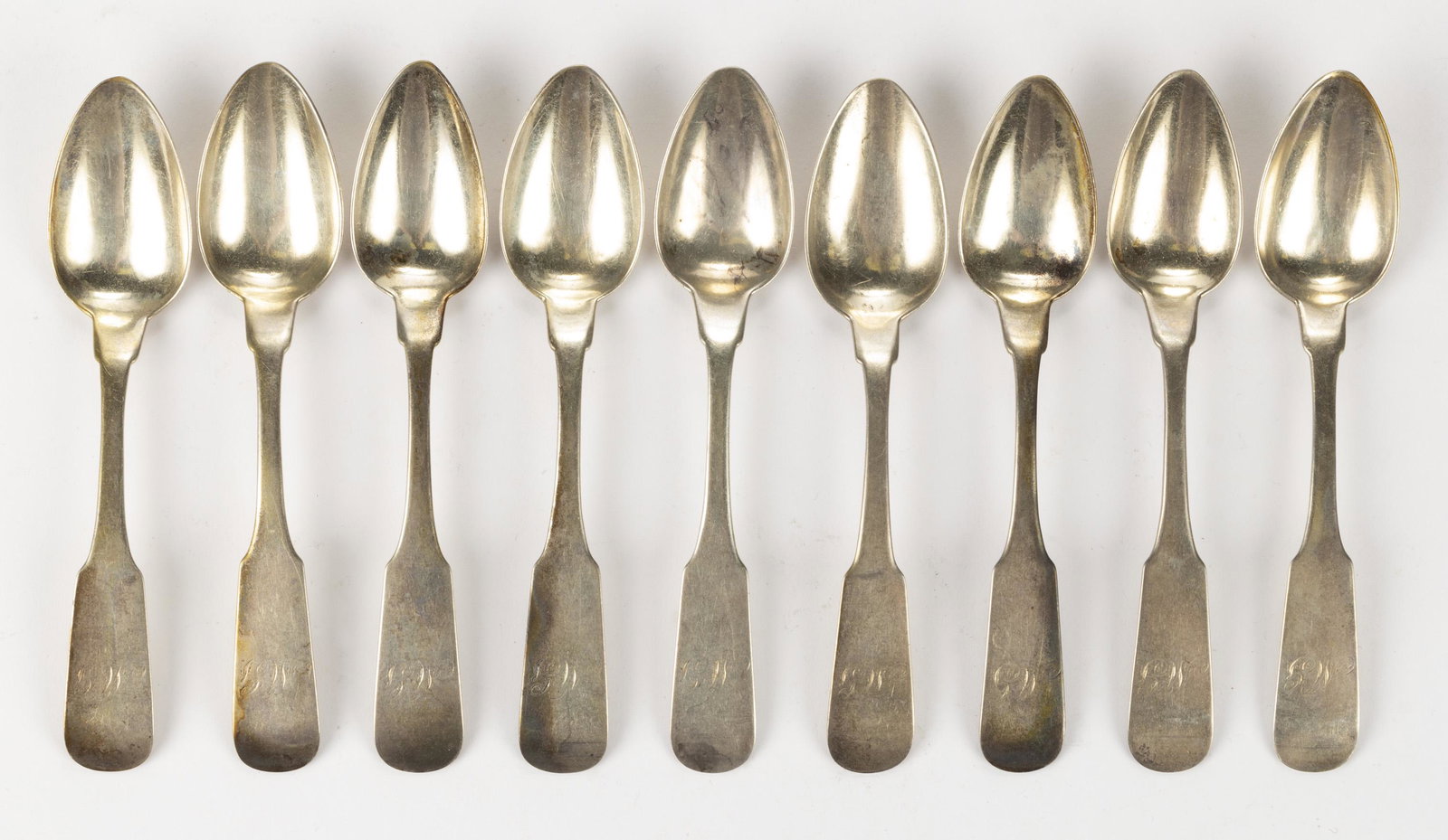 RICHMOND, VIRGINIA COIN SILVER TEASPOONS, SET OF NINE: RICHMOND, VIRGINIA COIN SILVER TEASPOONS, SET OF NINE, each having a pointed oval bowl on a backwards-tipped fiddle handle with pointed shoulders and engraved "MG" initials reportedly for the Gatewood