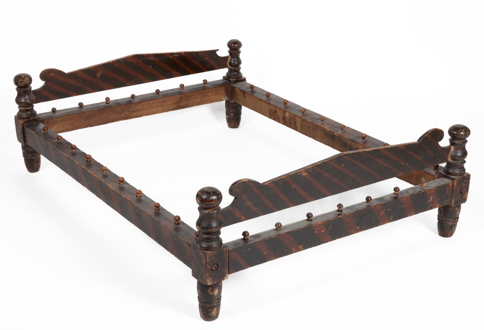 PENNSYLVANIA PAINT-DECORATED TRUNDLE BED: PENNSYLVANIA PAINT-DECORATED TRUNDLE BED, featuring cannon ball finials. Retains original paint-decorated surface. Circa 1830. 15 3/4" HOA, 40" WOA, 54 1/2" LOA. Shipping Note: IN-HOUSE SHIPPING IS NO
