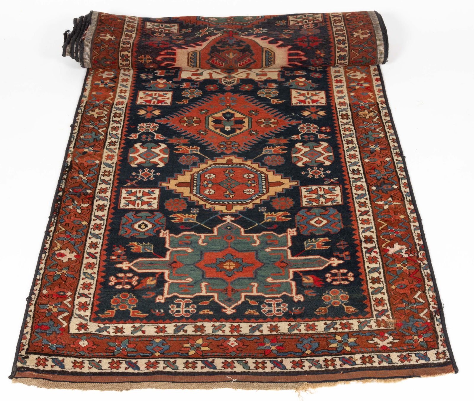 ANTIQUE PERSIAN KURDISH RUNNER: ANTIQUE PERSIAN KURDISH RUNNER, red and blue ground, with central medallions. Late 19th/early 20th century. 13' 2 1/4" x 3' 3 1/4".Provenance: From the collection of Kathy and Dr. Joseph Arvay, Mendha