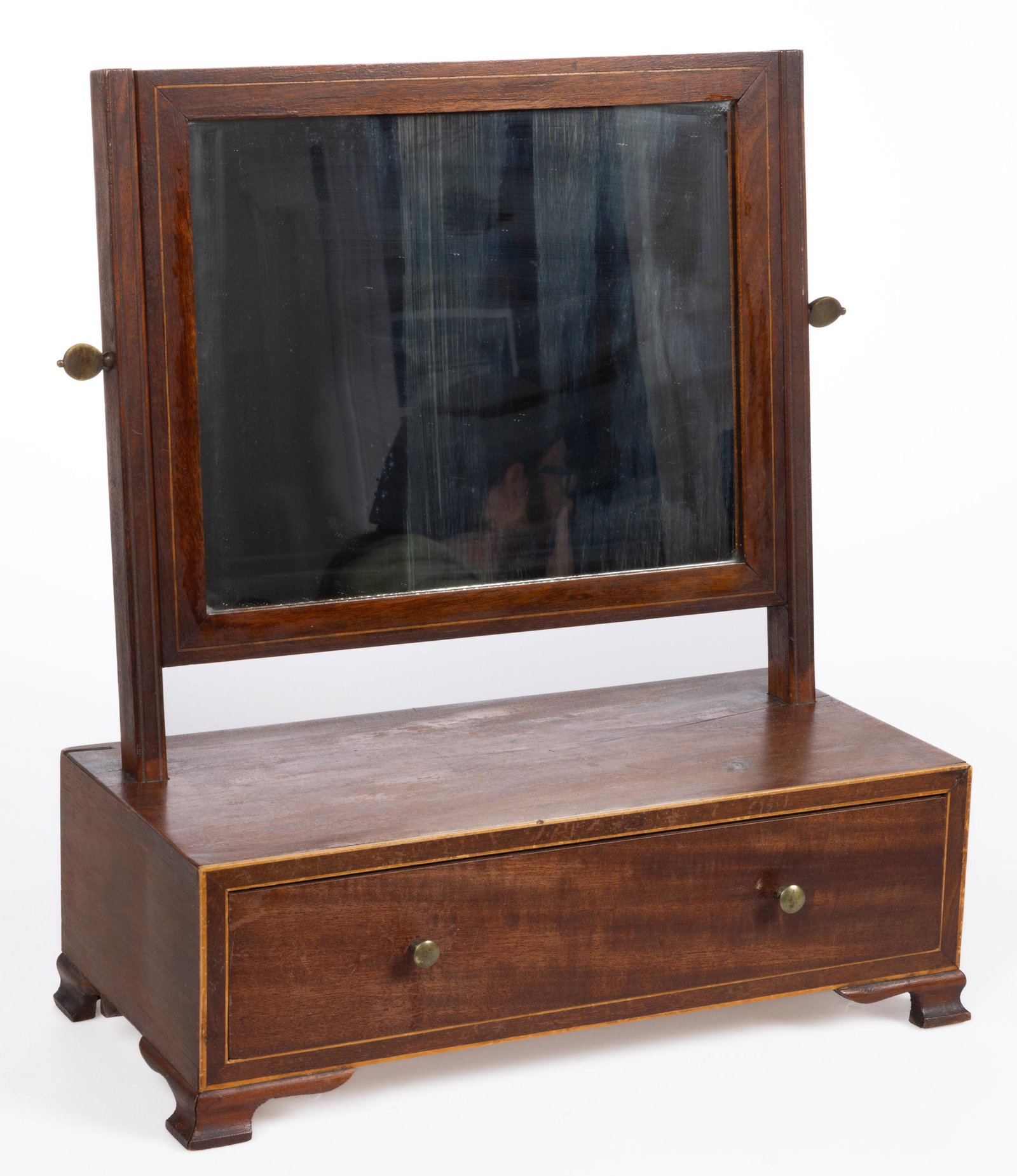 MID-ATLANTIC MAHOGANY TOILET / SHAVING MIRROR: MID-ATLANTIC MAHOGANY TOILET / SHAVING MIRROR, single dovetailed drawer, lightwood edging, raised on ogee-molded feet, with likely original mirror plate. White pine secondary wood. Retains an old surf