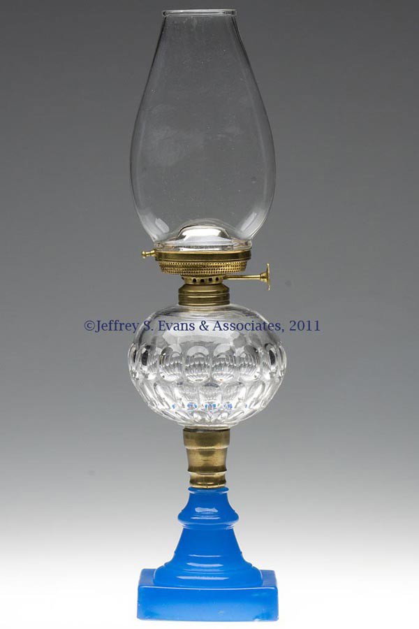 THUMBPRINT STAND LAMP: THUMBPRINT STAND LAMP, colorless font, translucent starch blue No. 2 base, brass connector, No. 1 Taplin-Brown collar. Fitted with a Holmes, Booth & Haydens Pinafore No. 1 lip burner, thumbwheel marke