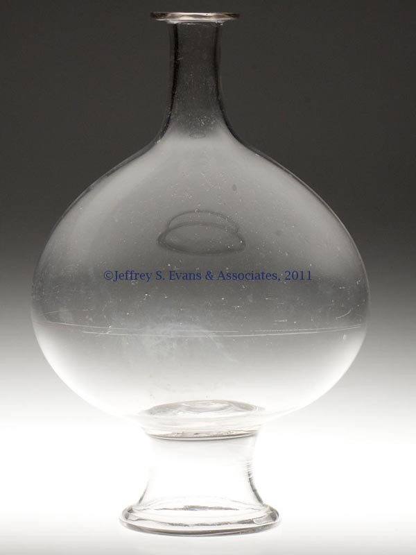 FREE-BLOWN SHOW GLOBE: FREE-BLOWN SHOW GLOBE, colorless, slightly compressed globular bottle raised on a funnel-form foot with a folded rim and rough pontil mark, bottle neck not ground for a stopper. United States. 1840-18
