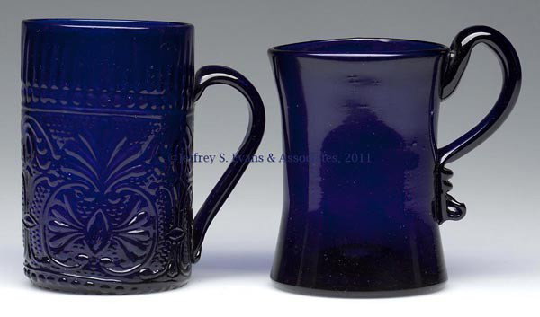 BLOWN-MOLDED AND FREE-BLOWN MUGS, LOT OF TWO: BLOWN-MOLDED AND FREE-BLOWN MUGS, LOT OF TWO, cobalt blue, cylindrical form example molded with an unlisted plume and fleur-de-lis pattern, each with an applied handle and rough pontil mark. 19th or 2