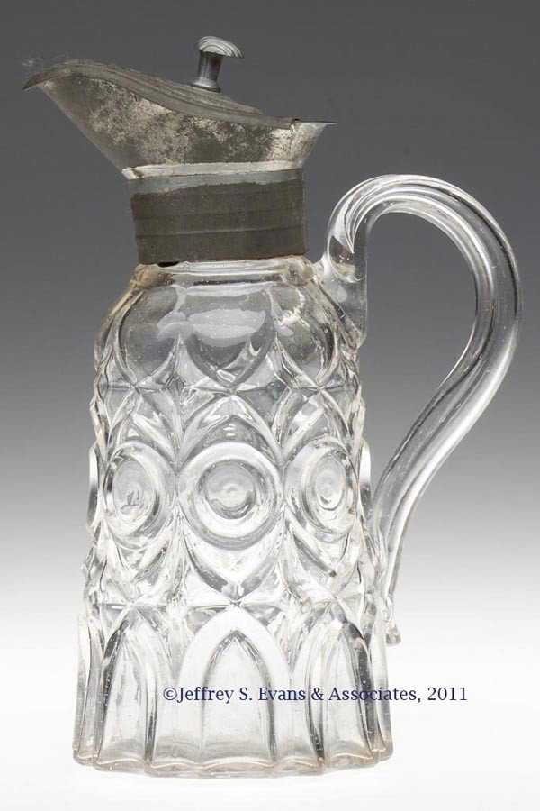BLOWN-MOLDED EXCELSIOR MOLASSES CAN / JUG: BLOWN-MOLDED EXCELSIOR MOLASSES CAN / JUG, colorless, slightly tapered cylindrical body with a medial ring of eight bull's eyes, applied hollow handle with crude flattened curl, and a plain base. Orig