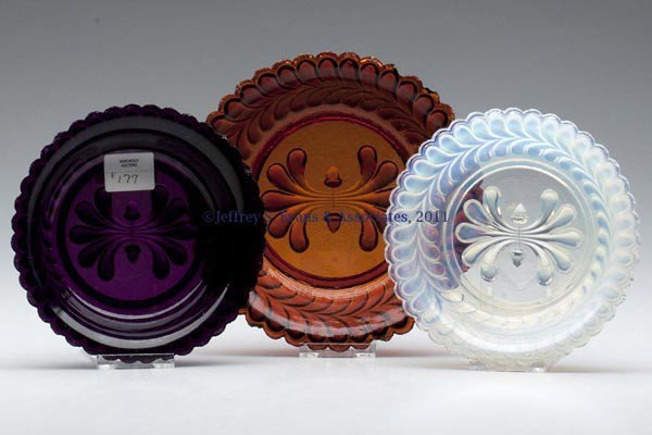 THREE PRESSED PLUME AND ACORN NAPPIES: THREE PRESSED PLUME AND ACORN NAPPIES, deep amethyst, root beer amber and fiery opalescent, each with an even-scallop rim. Boston & Sandwich Glass Co. 1840-1860. 5" and 6" D. Literature: B & K I, fig.