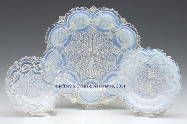 THREE PRESSED ROMAN ROSETTE ARTICLES: THREE PRESSED ROMAN ROSETTE ARTICLES, fiery opalescent, comprising two nappies and a plate, each with a central nine-petal rosette. Boston & Sandwich Glass Co. and others. 1838-1850. 3 1/2" to 6 1/8" 