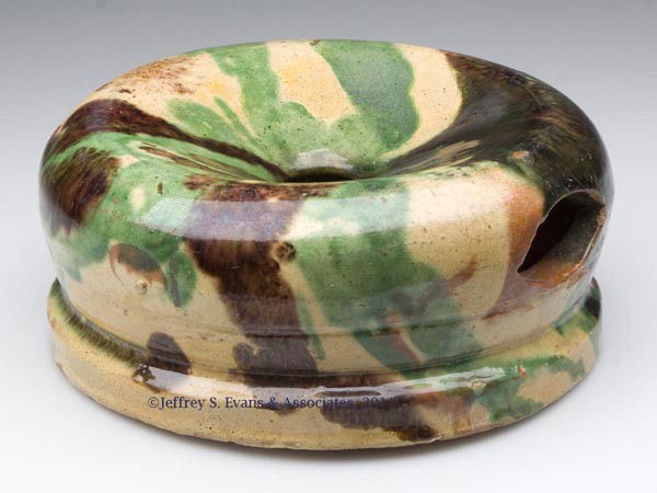 STRASBURG, VA POLYCHROME-DECORATED EARTHENWARE SPIT: STRASBURG, VA POLYCHROME-DECORATED EARTHENWARE SPITTOON, copper, manganese and lead glazes over a slip wash, low form with rounded shoulder, cut-out drain hole, and pronounced squared foot. Attributed