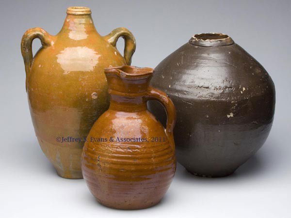 THREE ASSORTED EARTHENWARE LARGE UTILITARIAN ARTIC: THREE ASSORTED EARTHENWARE LARGE UTILITARIAN ARTICLES, two lead glazed, the pitcher with incised undulating line on shoulder. 19th and possibly 20th century. 12 1/2" to 17 1/2" H. Provenance: Collecti