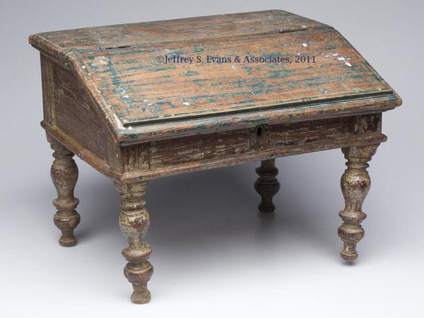 COUNTRY SHERATON SLANT-LID TABLE-TOP BOX: COUNTRY SHERATON SLANT-LID TABLE-TOP BOX, hinged lifting front concealing a simple divided interior, raised on tall well-turned feet. Partially scraped overpaint. First half 19th century. 12" HOA, 16 
