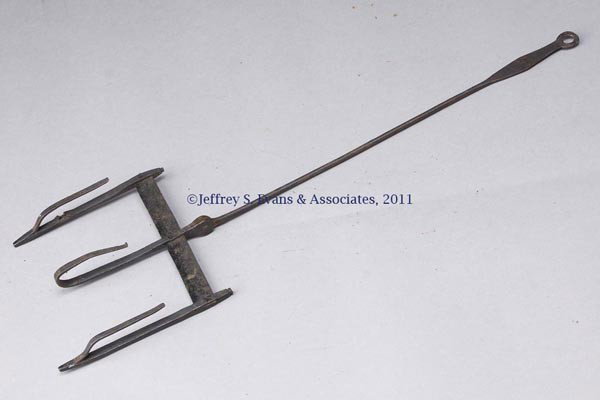 WROUGHT-IRON TOASTER: WROUGHT-IRON TOASTER, outer two supports of frame extended to form feet, loosely riveted to handle with a loop at the end. First half 19th century. 7 1/2" HOA, 8" W, 24 1/2" LOA. Provenance: Estate co