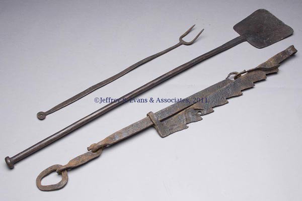 THREE WROUGHT-IRON HEARTH ARTICLES: THREE WROUGHT-IRON HEARTH ARTICLES, comprising a peel, long fork and trammel. 19th century. Peel 41" L. Provenance: Estate collection of Dorothy and Marshall Jenkins.