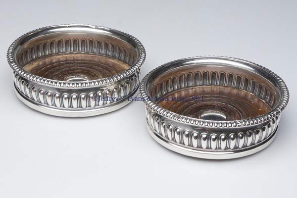 PAIR OF SHEFFIELD PLATE WINE COASTERS: PAIR OF SHEFFIELD PLATE WINE COASTERS, each with gadrooning to body and rim, wooden base. England. First half 19th century. 1 3/4" H, 5 3/4" DOA. Provenance: From a Williamsburg, VA collection.