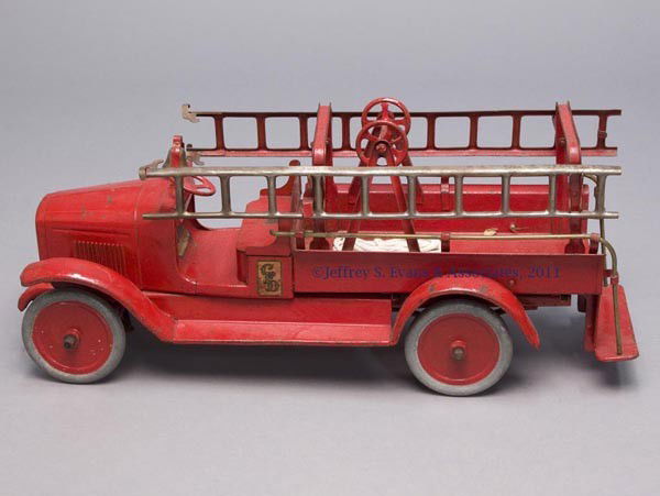 BUDDY "L" PRESSED STEEL HOOK AND LADDER TOY FIRE TR: BUDDY "L" PRESSED STEEL HOOK AND LADDER TOY FIRE TRUCK solid metal wheels and tires with operable steering wheel, open cab with brass bell, open bed with ladder hooks fitted with two ladders. Red pain