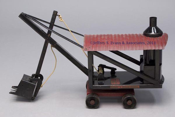 BUDDY "L" PRESSED STEEL TOY STEAM SHOVEL: BUDDY "L" PRESSED STEEL TOY STEAM SHOVEL body fitted on four cast wheels, bucket in working condition, boiler without door, as made. Original dark red paint with some later touch-ups, black is repaint