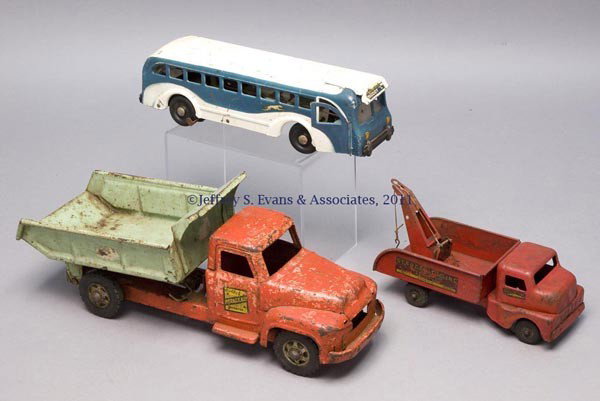 VARIOUS MANUFACTURERS PRESSED STEEL TOY TRUCKS, LOT: VARIOUS MANUFACTURERS PRESSED STEEL TOY TRUCKS, LOT OF THREE comprising a Buddy L Greyhound Lines bus with original paint and labels to each side, clockwork activated mechanism in unknown working cond