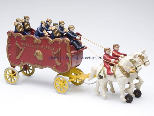 KENTON "OVERLAND CIRCUS" CAST-IRON TOY BAND WAGON: KENTON "OVERLAND CIRCUS" CAST-IRON TOY BAND WAGON with nine original figures and original paint. First half 20th century. 7 1/4" H, 16" L. Provenance: Estate collection of Dorothy and Marshall Jenkins