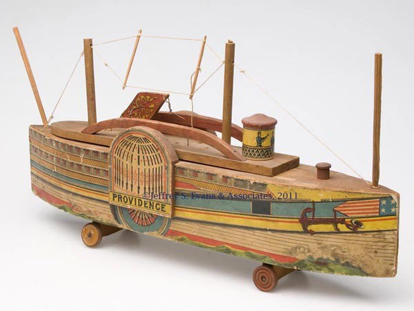 REED "PROVIDENCE" STEAMBOAT TOY: REED "PROVIDENCE" STEAMBOAT TOY lithographed paper on wood, variant with pointed stern, lift-off top, patent information stamped underneath. Not marked. Attributed to the W. S. Reed Toy Co., Leominste