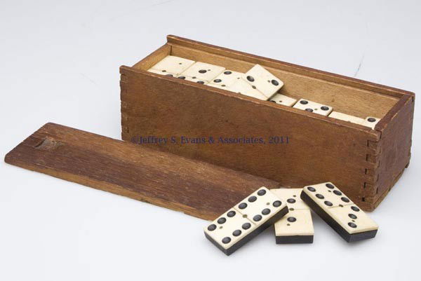 SET OF EBONY AND IVORY / BONE DOMINOES: SET OF EBONY AND IVORY / BONE DOMINOES 28 pieces stored in a slide-top wooden box. Late 19th/early 20th century. 7/8" x 1 7/8", 2 3/8" x 7" box. Provenance: Estate collection of Dorothy and Marshall J
