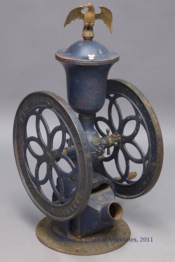 ENTERPRISE CAST-IRON TWO-WHEEL COFFEE MILL: ENTERPRISE CAST-IRON TWO-WHEEL COFFEE MILL swivel lid with eagle finial of unknown association, original tin container, "712" on plaque below the patent date, circular base, original paint. Late 19th/